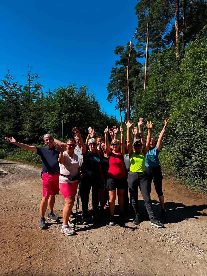 Le groupe bras levés sur un chemin forestier, au retour d'une sortie ensoleillée