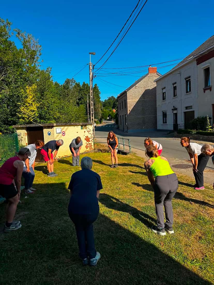 Échauffement en cercle sur une pelouse avant le départ de la séance